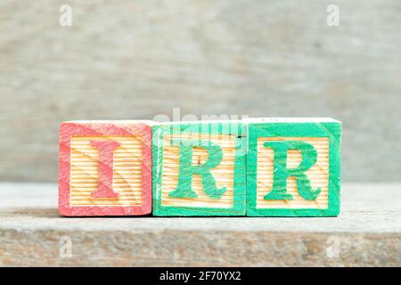 Color alphabet letter block in word IRR (Abbreviation of internal rate of return) on wood background Stock Photo