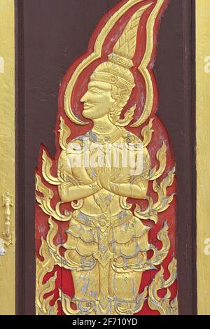 A heavenly being depicted on a door at Wat Mongkhon Nimit (Mongkon Nimit, Mongkol Nimit) in Phuket Town, Thailand, performing a 'wai' (trad. greeting) Stock Photo
