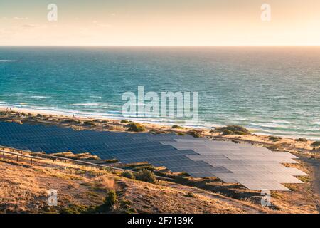 Solar panels installed along the coastline at sunset in South Australia Stock Photo