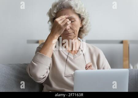 Mature pensioner tired of working at laptop from home Stock Photo