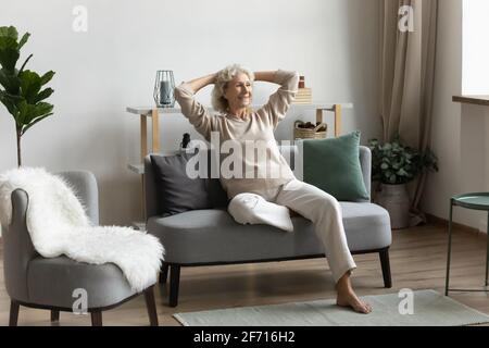 Happy middle aged 60s pensioner spending leisure time at home Stock Photo
