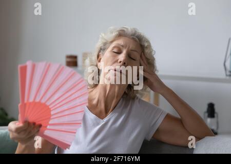 Mature senior woman exhausted with heat, swelter, summer weather Stock Photo