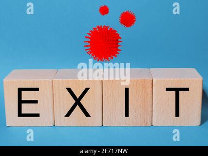 Cubes and dice with text Exit, with corona virus icons on blue background. Stock Photo