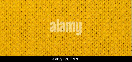 Yellow synthetic knitted fabric close up. Knitted fabric texture background Stock Photo