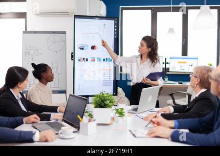 Executive director woman briefing collegues, explaning company strategy during brainstorming. Multiethnical businesspeople working in professional startup financial office during conference meeting Stock Photo