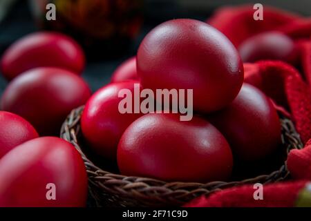 A closeup of Easter eggs in a wicker basket dyed in the traditional red colour. Stock Photo