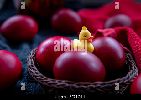 A closeup of Easter eggs in a wicker basket dyed in the traditional red colour. Stock Photo
