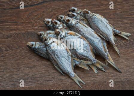 some dried fish on a dark wooden background/ Stock Photo