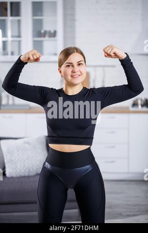 A beautiful athletic woman in a black top and leggings demonstrates a  slender figure. Motivation to go in for sports. Healthy lifestyle Stock  Photo - Alamy