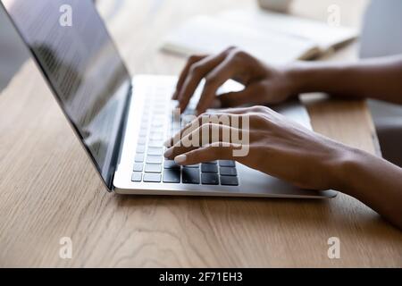 Close up of biracial woman typing on laptop Stock Photo