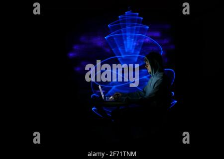 Man using technology with laptop. Abstract light form in the background, made to lightpainting. Stock Photo