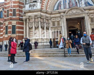 London, UK. 4th April 2021. Congregation exiting Westminster Cathedral, London, following the 10am Easter Sunday Mass celebrated by Roman Catholics. Cathedral chaplains greet and bless parishioners. Stock Photo