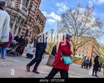 London, UK. 4th April 2021. Congregation exiting Westminster Cathedral, London, following the 10am Easter Sunday Mass celebrated by Roman Catholics. Cathedral chaplains greet and bless parishioners. Stock Photo