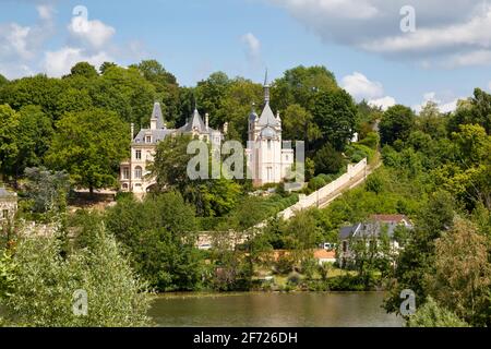 Pierrefonds, France - May 25 2020: The castle of Jonval was built on the ruins of an old medieval castle opposite the lake. The building has been clas Stock Photo