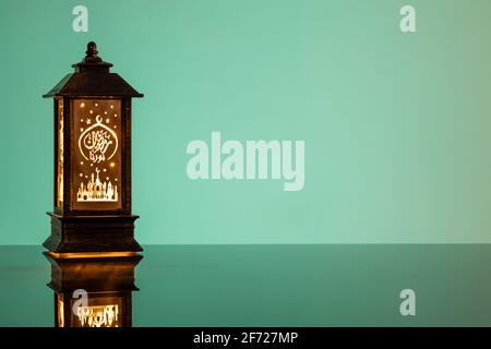 Eid Mubarak concepts with lamp inscribed with arabic text translated to english as Ramadhan is our light. Stock Photo