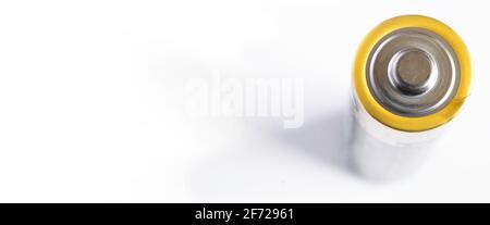 Close-up of an upright penlight battery on white with shadow, focus on the battery head. Narrow depth of field, wide image Stock Photo