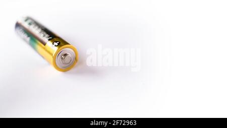 Close-up of a lying penlight battery on white, focus on the battery head. Narrow depth of field, wide image Stock Photo