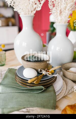 A beautiful table setting with crockery for the celebration of Easter. Egg on a plate Stock Photo
