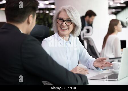 Smiling diverse employee discuss ideas in office Stock Photo