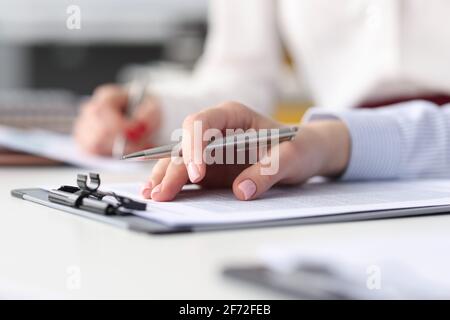 Hands of employees with documents and pens at work table Stock Photo