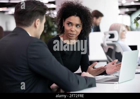 Multiethnic employees brainstorm using laptop in office Stock Photo