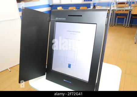 People with masks are voting electronic on a machine for Bulgarian parliamentary elections in Sofia, during coronavirus pandemic, in Sofia, Bulgaria o Stock Photo