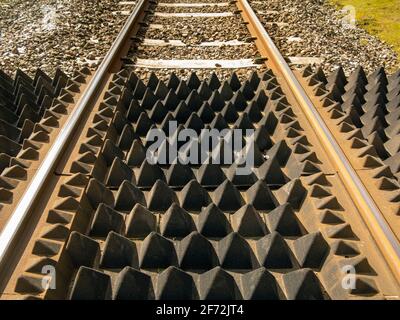 A section of rail track at a footpath crossing showing anti-trespass panels Stock Photo