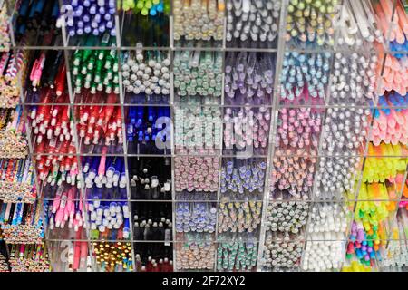 Colored pens, pencils and markers on shelves in shop. Office supplies and stationery. Colorful pens arranged on shelf. Multicolored pens in art store. Stock Photo