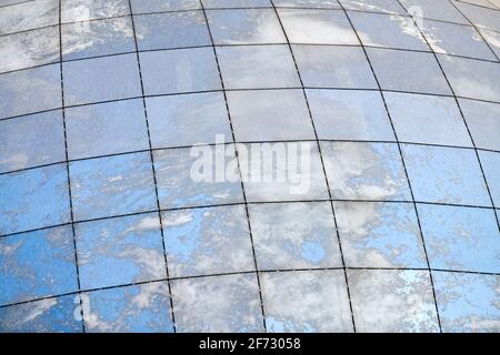 Glass spherical modern building with reflection of blue sky and clouds. Stock Photo