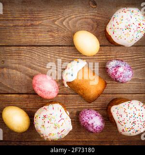 Easter cakes and Easter colored eggs on a wooden background. Religious holiday of bright Easter. Stock Photo