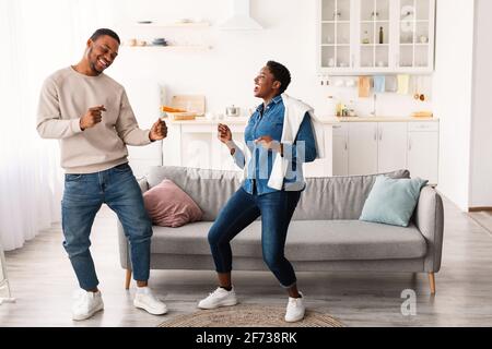 Portrait of joyful black couple dancing at home Stock Photo