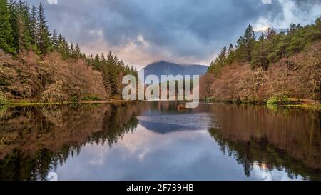 Beautiful landscape image of Glencoe Lochan with Pap of Glencoe in the distance on a Winter's evening
