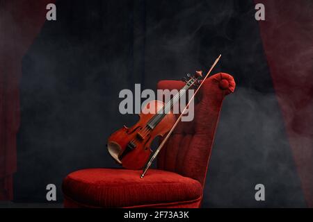 Violin in retro style and bow on the chair, nobody Stock Photo