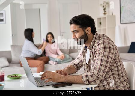 Young indian man father remote working online from home office with family. Stock Photo