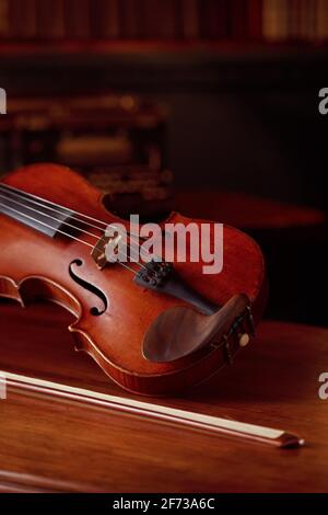 Violin in retro style and bow on wooden table Stock Photo
