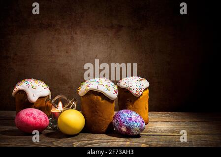 Easter cakes and Easter colored eggs on a dark background. Religious holiday of bright Easter. Stock Photo