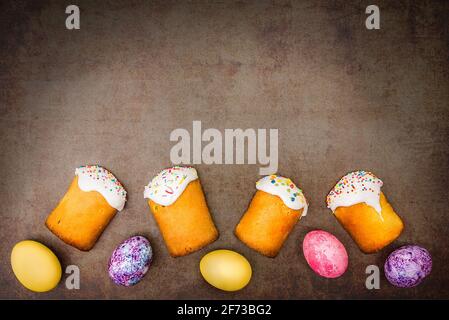 Easter cakes and Easter colored eggs on a dark background. Religious holiday of bright Easter. Stock Photo