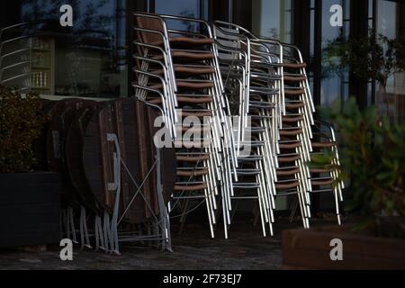 furniture (stools, tables) of a closed outside area of a café restaurant during corona lockdown in Germany Stock Photo