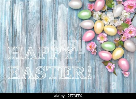 Happy Easter! Easter eggs and spring flowers on blue wooden background Stock Photo