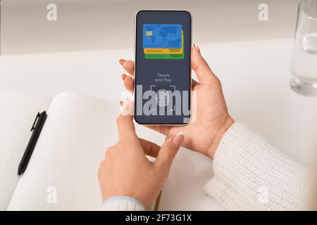 Unrecognizable woman paying online with Touch ID, using smartphone Stock Photo