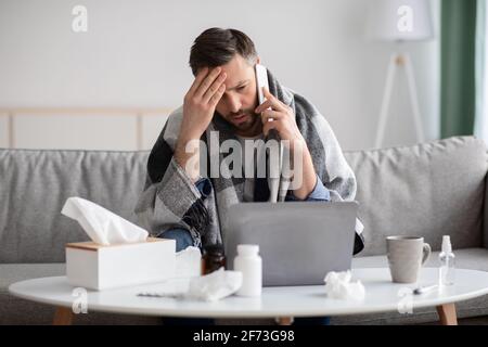 Ill man suffering from fever, calling his doctor Stock Photo