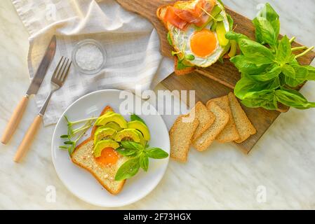 Tasty fried eggs with bread and avocado on table Stock Photo