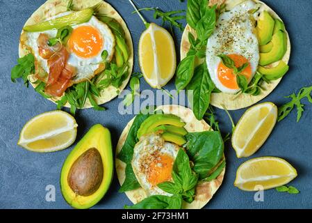 Tasty flatbread with egg and avocado on dark background Stock Photo