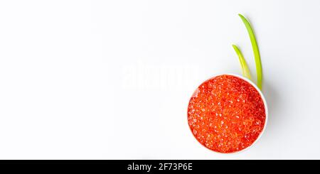 Red caviar in a wooden cup on a white background with a spoon. Place for advertisement, logo, label, mockup, mock-up. Stock Photo