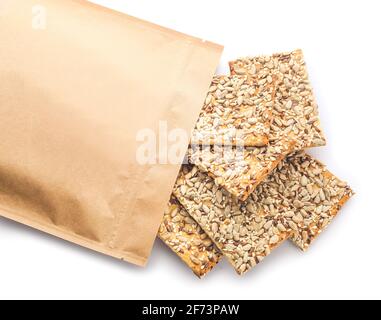 Tasty crackers with seeds in bag on white background Stock Photo