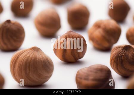 Hazelnuts scattered on a white background, whole, selective focus. The concept of healthy eating. Stock Photo