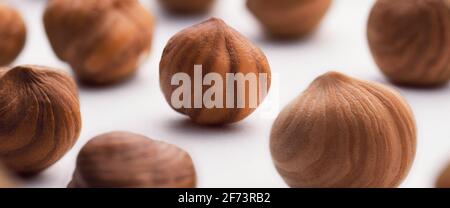 Hazelnuts scattered on a white background, whole, selective focus. The concept of healthy eating. Stock Photo