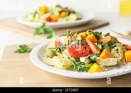 Plates of fresh salad with vegetables on light wooden background Stock Photo