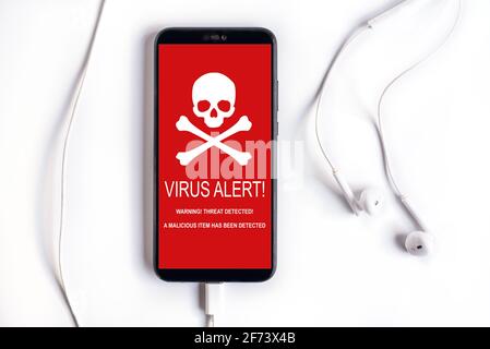 Phone with warning virus alert alarm on screen. Malware notification on smartphone. Security mobile concept, security risk. Stock Photo