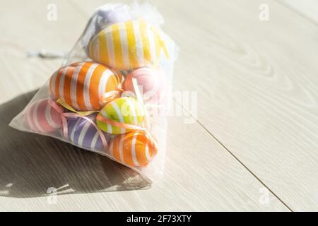 multi-colored chicken eggs in bag mesh on white background. easter Stock Photo